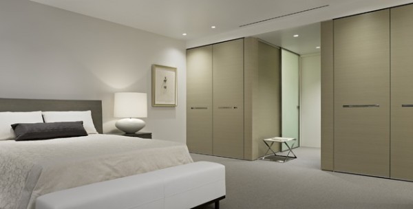 Simple-intérieur-de-la-chambre-contemporaine-avec-large-lit-et-blanc-banc-près-fantastique-maître-chambre-placard-idées