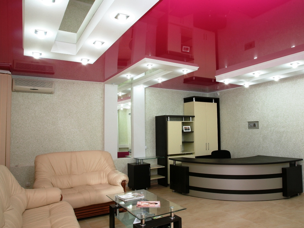 Pluses of a stretch ceiling of red color with white inserts for a large living room