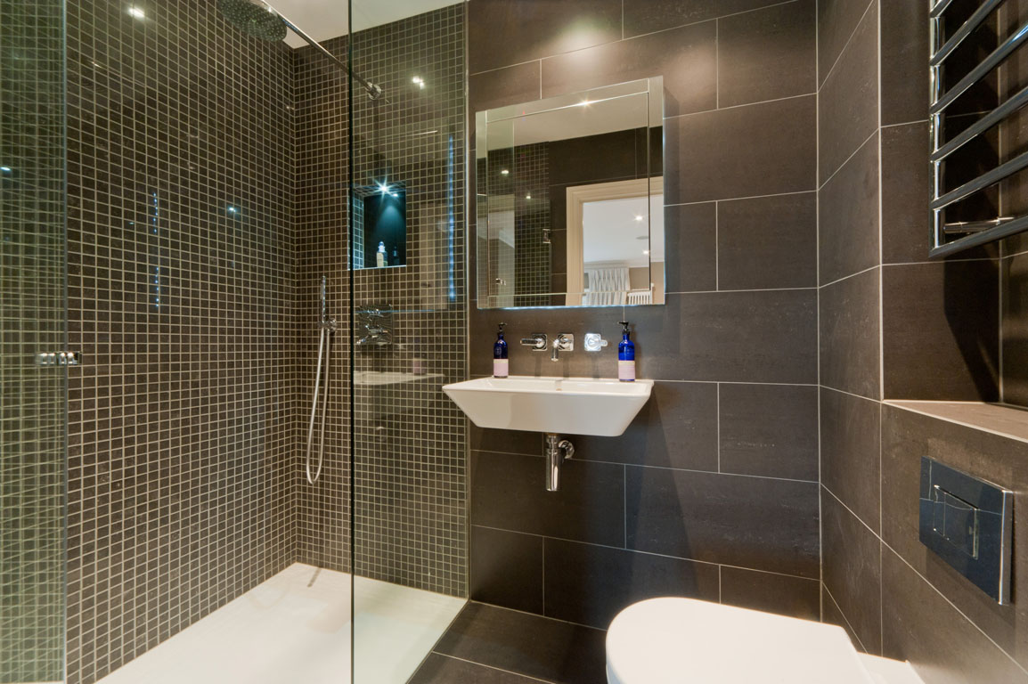 décor lumineux d'une salle de bain avec douche aux couleurs sombres
