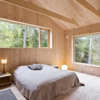 camera da letto in una casa di legno con finestre