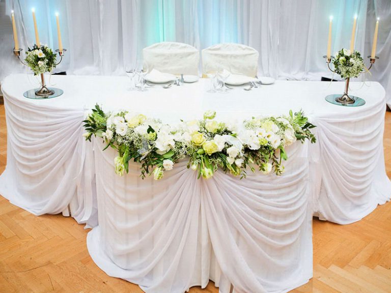 Tavolo per matrimonio con tessuto bianco decorato e candelieri