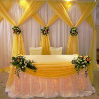 Tessuti gialli e beige nel design del tavolo di nozze