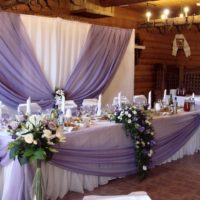 Mazzi di rose bianche agli angoli del tavolo del matrimonio