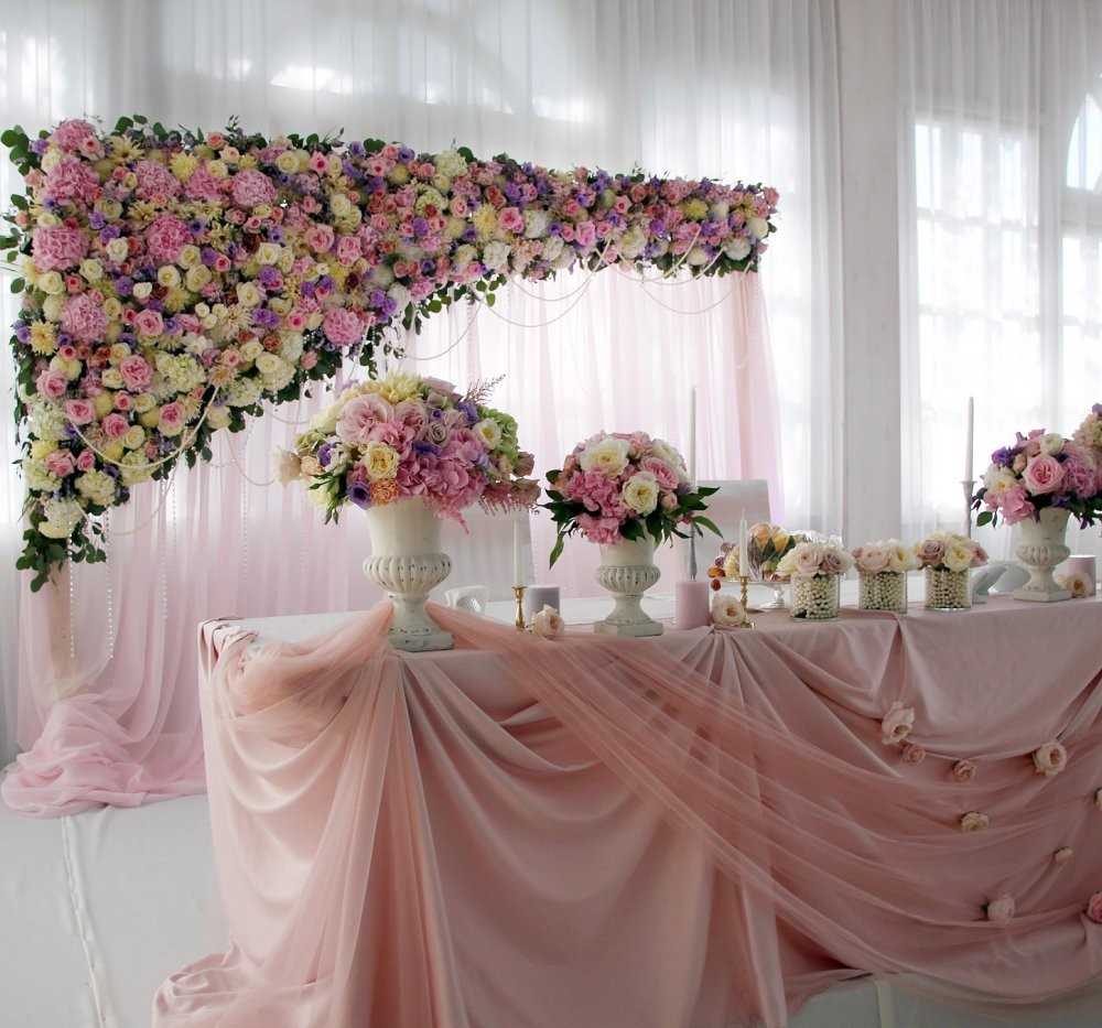 Decorazione della tavola di nozze con colori chiari e tessuto traslucido.