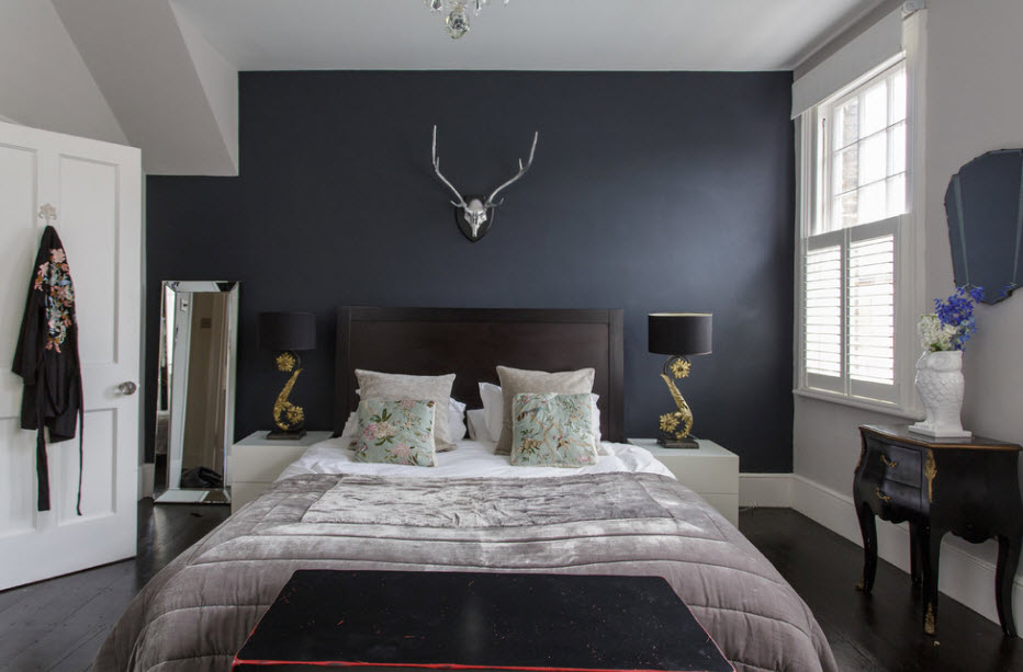 Bedroom with a dark bed and a light bedspread