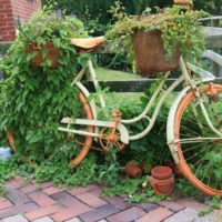 Senas dviratis retro gėlių lovų vaidmenyje