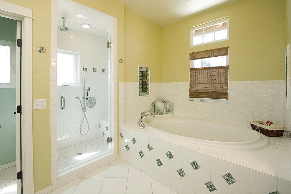 Комбинацията от бели и светло зелени плочки в интериора на банята