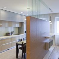 La suddivisione in zone della cucina-soggiorno con una parete decorativa con rifiniture in legno