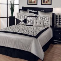 Fekete ágy fehér takaróval a városi apartman hálószobájában