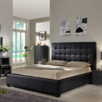Zwart bed en grijswitte muren in de slaapkamer