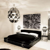 Fekete ágy, fehér párnákkal, világosszürke szobában