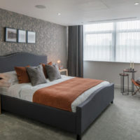 Gray bedroom and orange bedspread