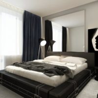 Spotlight on a tripod in a bedroom with a black bed
