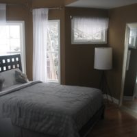 Gray bedspread and dark brown bedroom walls