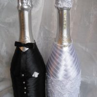 Costume noir et robe blanche sur les bouteilles de la mariée et du marié