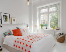 Bijela spavaća soba i narančasti jastuk