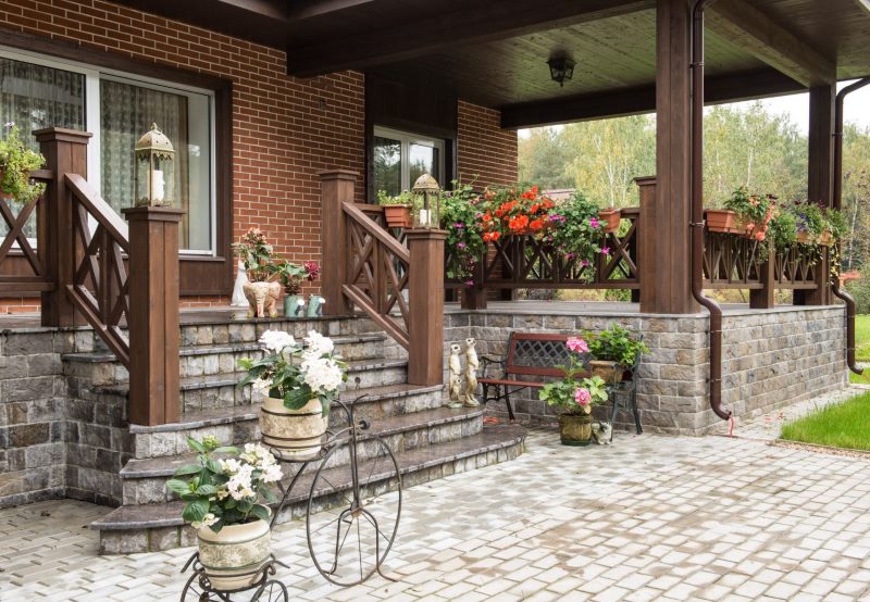 Decorare il portico di una casa di campagna con pietra e legno