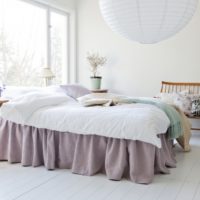 Chambre blanche avec couvre-lit lavande