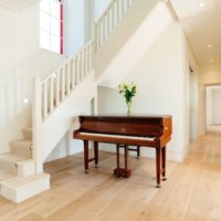 Sala bianca con un pianoforte in una casa di campagna