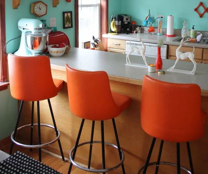 Chaises orange le long du comptoir du bar dans la cuisine