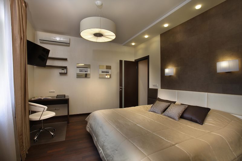 Lighting in a dark bedroom with a chandelier and built-in lamps