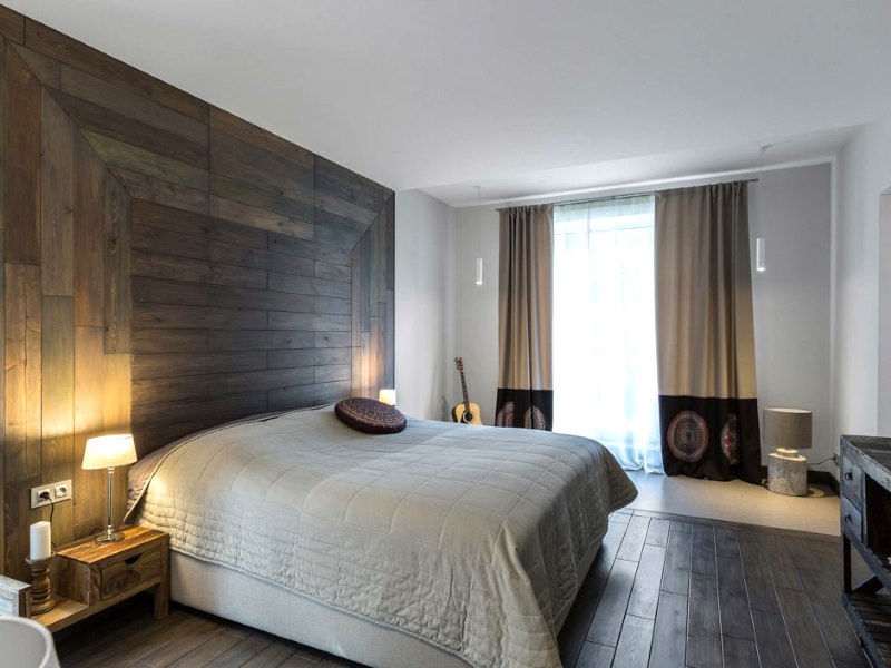 Décoration murale derrière la tête du lit avec du bois dans une chambre de style contemporain