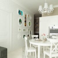 Salon cuisine blanc avec mur de briques.