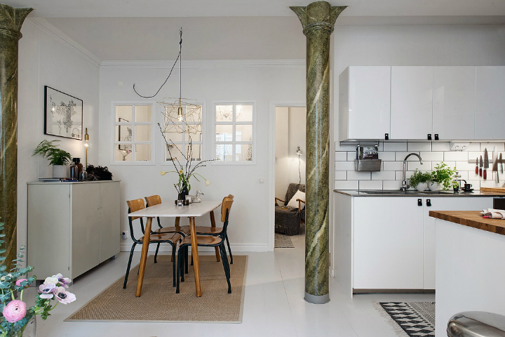 Interno cucina-soggiorno in stile scandinavo con colonna in marmo