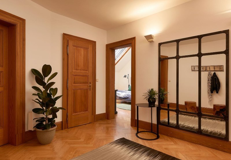 Ingresso di una casa privata con pavimento marrone e porte in legno