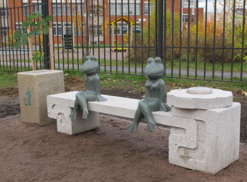 Figures of frogs sitting on a decorative bench