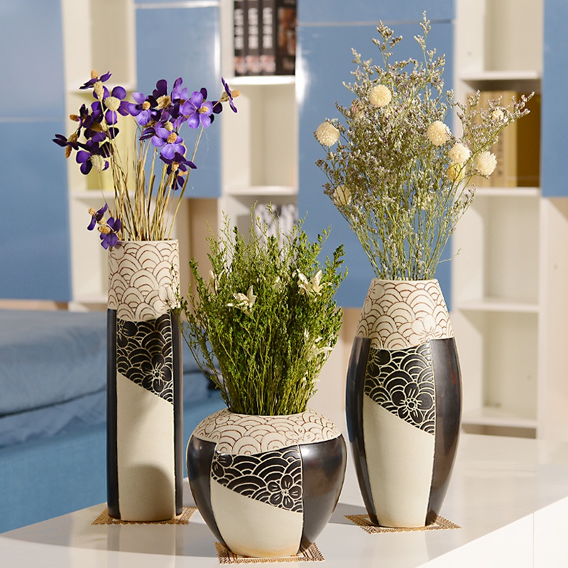 Black and white floor vases with plants