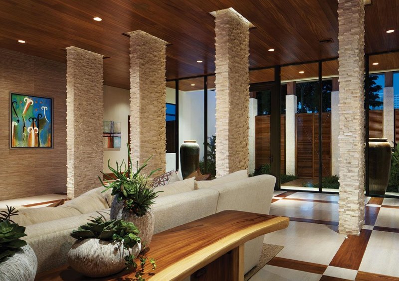 La suddivisione in zone dello spazio del soggiorno con colonne in pietra naturale