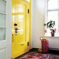 Tapis coloré devant la porte jaune dans le couloir