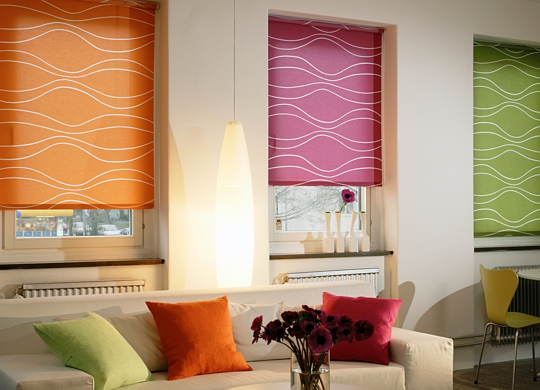 Three windows with roller blinds in various colors