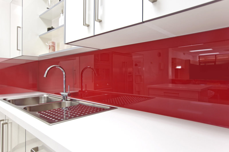 Tablier acrylique rouge dans la cuisine blanche