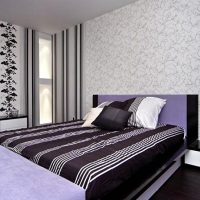 Couvre-lit rayé dans la chambre à coucher avec deux types de papier peint