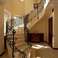 Escalier avec balustrade forgée dans le couloir d'une maison de campagne