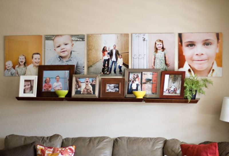 Étagère avec des photos de famille sur le mur du salon