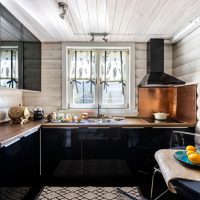 Cuisine avec des meubles noirs dans une maison en bois