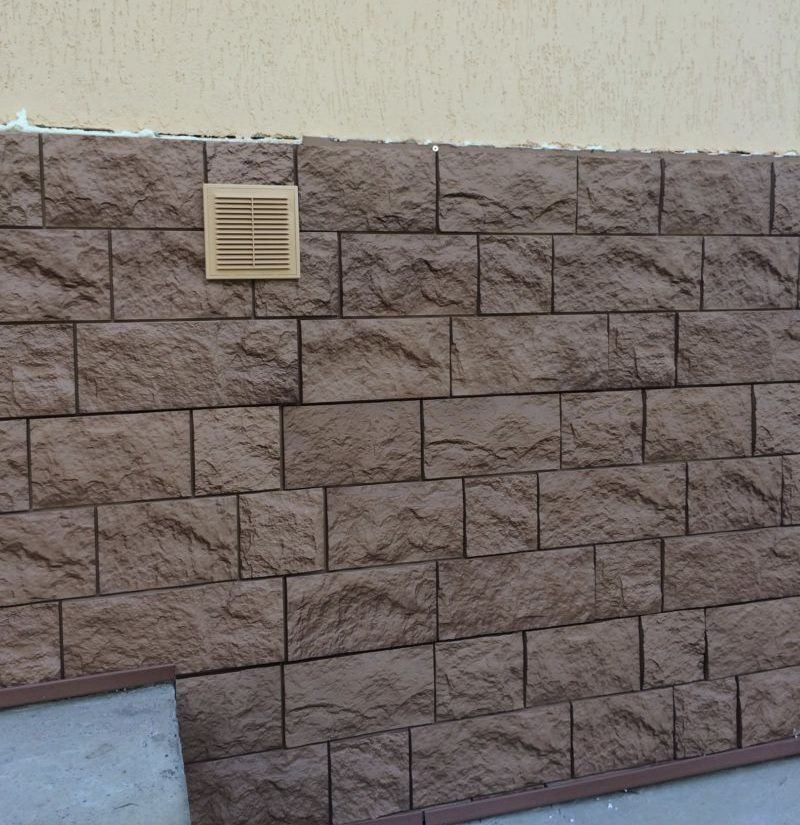 Finitura con pietra artificiale nel seminterrato di un edificio residenziale