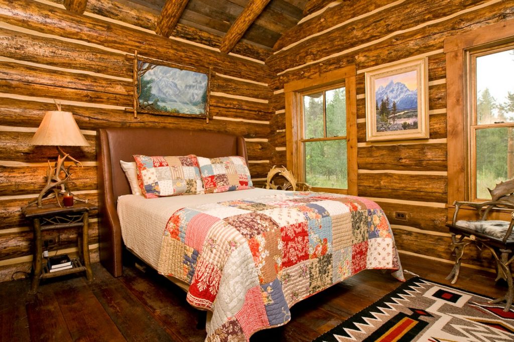 Couvre-lit varié à partir de rabats en tissu sur un lit dans une maison en rondins