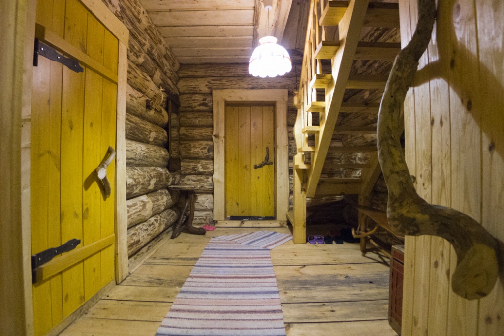 Intérieur d'un hall d'entrée avec un escalier dans une maison en rondins
