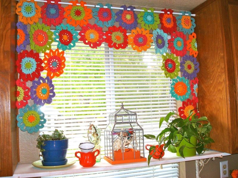 Decorare una finestra della cucina con tovaglioli multicolori fatti di filo