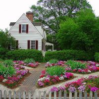 Цветни лехи в предната градина на селска къща