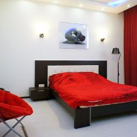 Raudonas fotelis moderniame miegamajame