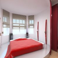 Piros ágytakaró az ágyon egy fehér hálószobában