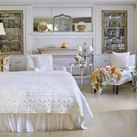 Krevet s bijelim pokrivačem u prostranoj spavaćoj sobi