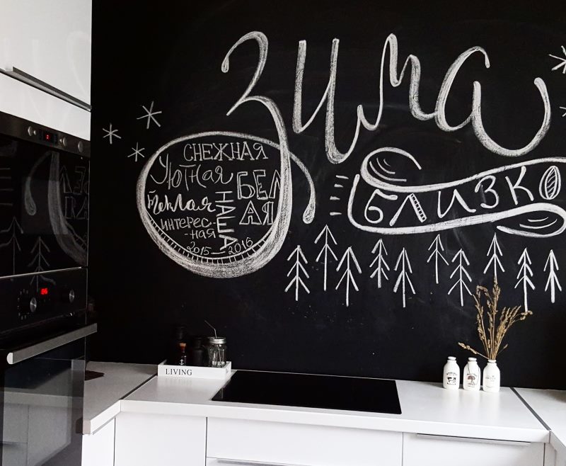 Chalk inscriptions on a black kitchen wall
