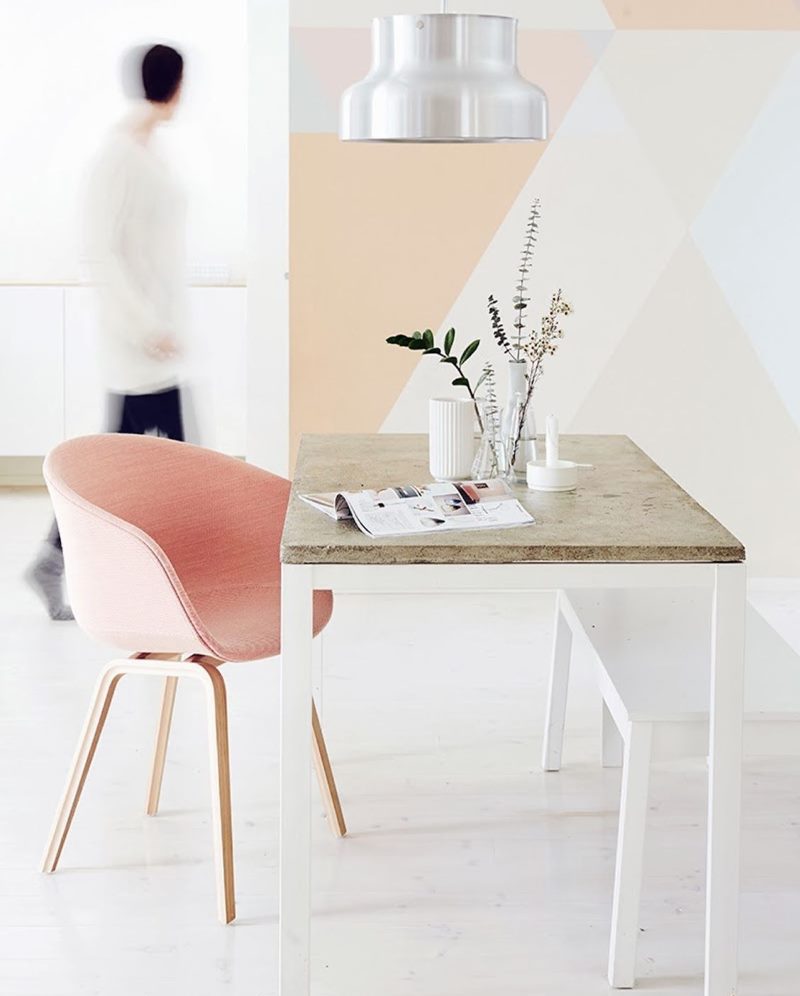 Rožinis fotelis minimalistinio stiliaus gyvenamajame kambaryje