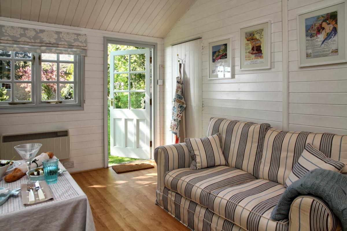 Canapé avec tapisserie d'ameublement rayée dans la chambre d'une petite maison de campagne